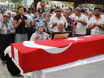 <p><font face="verdana,geneva" size="2">Ardından şehit polis memuru Ahmet Sargın'ın T&uuml;rk bayrağına sarılı cenazesi, meslektaşlarının omuzlarında t&ouml;ren alanına getirildi. Cenazenin getirilişi sırasında yakınları g&ouml;zyaşlarına boğulurken, &ouml;nce kız kardeşi Zeynep Başpınar ardından anne ve babası ile eşi Ayşe Sargın tabuta sarılarak ağladı. Oğlunun fotoğrafını defalarca &ouml;p&uuml;p koklayan anne Fatma Sargın'ı yakınları teselli etmeye &ccedil;alıştı.&nbsp;&nbsp;</font></p><p><font face="verdana,geneva" size="2">Sargın'ın &ouml;zge&ccedil;mişi okundu. T&ouml;ren Mersin M&uuml;ft&uuml;s&uuml; Niyazi Ersoy'un yaptığı duanın ardından sona ererken, şehidin cenazesi bir s&uuml;re meslektaşlarının omzunda cenaze aracına kadar taşındı. Cenazenin taşınması sırasında şehit polisin b&uuml;y&uuml;k oğlu Burak, babasının fotoğrafı ile &ouml;n safta yer aldı. Şehidin cenazesi daha sonra doğum yeri olan Kocavilayet K&ouml;y Mezarlığı'na defnedildi. </font></p>