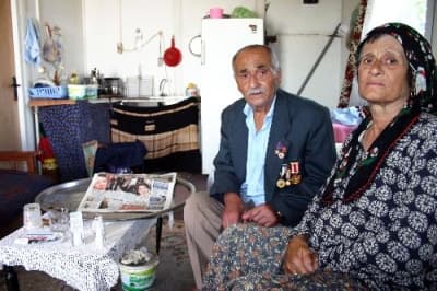 <font face="arial,helvetica,sans-serif" size="2">Eşinin ve kendisinin bakıma ihtiya&ccedil;larının olduğunu vurgulayan Tuna, aylık 395 YTL olan gazi maaşının ihtiya&ccedil;larına yetmediğini ifade etti. Yaşadığı yerin hastaneye &ccedil;ok uzak olduğunu anlatan Tuna, şunları s&ouml;yledi: &quot;T&uuml;berk&uuml;loz hastasıyım. Fenalaştığım zaman kendi imkanlarımla hastaneye gidemiyorum. 112 ambulansıyla beni hastaneye g&ouml;t&uuml;r&uuml;yorlar. Doktorlar bana sağlıklı bir ortamda yaşamam gerektiğini s&ouml;yledi. Ancak gidecek bir yerim yok. Eşim de şeker hastası ve ayaklarında yaralar &ccedil;ıktı. İkimizin de bakıma ihtiyacı var. Depremden &ouml;nce yaşadığım k&ouml;ye bir prefabrik koymak istedim. Ama k&ouml;yl&uuml;ler izin vermediler. Yerim olmadığı i&ccedil;in kuramadım prefabriği. Tek isteğim eşimle birlikte bir evde kalmak. Devletten ve hayırseverlerden yardım bekliyorum&quot;</font>