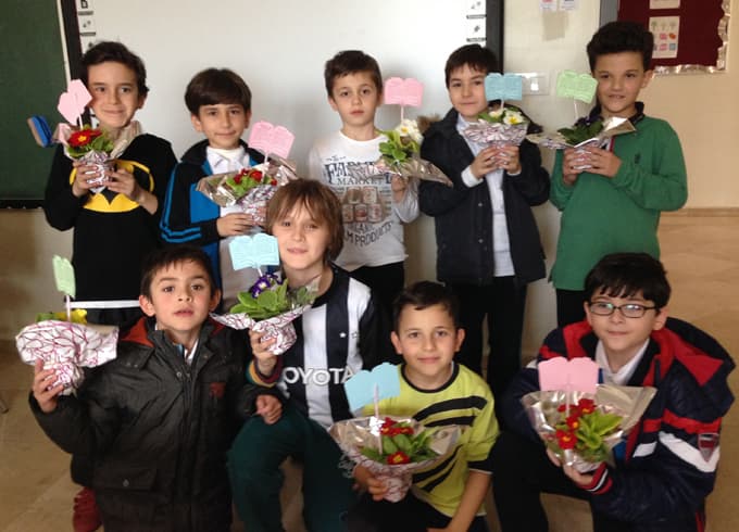 Öğretmenlerinin hediye ettiği çiçeklere kitap okuyorlar