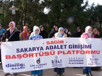 <p><font face="arial,helvetica,sans-serif" size="2"><strong>A&ccedil;ıklamayı Vahdet Vakfı'ndan Yusuf Arslan okudu. A&ccedil;ıklamanın tam metni:</strong>&nbsp;</font></p><p><font face="arial,helvetica,sans-serif" size="2">G&uuml;ndeme getirdiği her konu ile adeta<font color="#333399">, &quot;yasak&ccedil;ılığın takip&ccedil;isi&quot;</font> ve <font color="#333399">&quot;&ouml;zg&uuml;rl&uuml;klerin &ouml;n&uuml;ndeki en b&uuml;y&uuml;k engel&quot;</font> olduğunu isbat eden ana muhalefet partisi, &ccedil;arşaf ve t&uuml;rbanlı bayanlara 6 OK'lu rozet takarak, bir polemiğe daha imza atmıştır.</font><font face="arial,helvetica,sans-serif" size="2">&nbsp;</font></p><p><font face="arial,helvetica,sans-serif" size="2">Bir zamanlar birilerinin:<font color="#333399"> &quot;Bu memlekete Kom&uuml;nizm'in gelmesi gerekiyorsa, biz getiririz&quot;</font> dediği gibi, <font color="#333399">&quot;Bu memlekette baş&ouml;rt&uuml;l&uuml; ve &ccedil;arşaflıların siyasete katılımları gerekiyorsa, onu da ancak biz yaparız'</font> dercesine başlattığı <font color="#333399">&quot;din istirmarcılığı harekatı&quot;</font>&nbsp; ile ana muhalefet partisi dost-d&uuml;şman c&uuml;mle alemin oklarını, 6 OK &uuml;zerine &ccedil;ekmiştir.</font><font face="arial,helvetica,sans-serif" size="2">&nbsp;</font></p><p><font face="arial,helvetica,sans-serif" size="2">Ana muhalefet partisi genel başkanı: <font color="#333399">&quot;Sıra t&uuml;rbanlı ve &ccedil;arşaflı kadına geldiğinde:'Hanımefendi, size ben rozet takamam, kıyafetinizi değiştirin, &ouml;yle gelin' deseydim, o zaman ben demokrasiyi i&ccedil;ine sindirememiş, insani duygulardan kopmuş biri haline d&ouml;n&uuml;şt&uuml;ğ&uuml;m&uuml; hissederdim</font>&quot; diyor.</font><font face="arial,helvetica,sans-serif" size="2">&nbsp;</font></p>