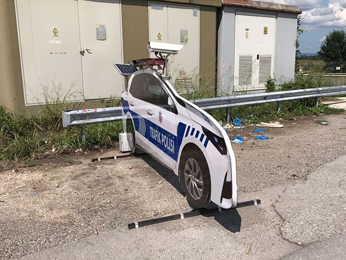 Kazalara 'dur' demek için yola maket polis aracı koydular