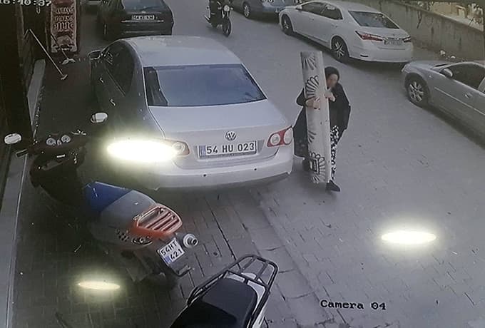 İş yerinin önündeki halıyı omuzlayarak kaçtı