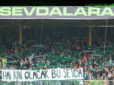 <p><font face="verdana,geneva" size="2"></font></p><font face="verdana,geneva"><font size="2">Bazen gurbetin soğuğunun insanın ciğerine işlediği zamanlarda, sağdan yapılan ortaya televizyon karşısında kafa vurmaya &ccedil;alışırken boyunlar tutuldu, top i&ccedil;eri girmeyince, yeşil ve siyah renklerden oluşan bir forma, g&ouml;zyaşlarıyla ıslandı oturulan koltukta.</font> </font><font size="2"><font face="verdana,geneva">&Ouml;ğrenci, dersine &ccedil;alışması gereken zamanda beste yaptı. Avukat, m&uuml;vekkilinin değil, hukuksuz i&ccedil;eri alınan kardeşlerinin savunmasına zaman ayırdı. M&uuml;hendis, hazırlaması gereken projeyi erteleyip, &quot;Sakaryaspor'un Yeniden Yapılandırılması Projesi&quot; &uuml;zerine ter d&ouml;kt&uuml;. Bu sevdanın her kademesi işinden, eşinden, &ccedil;ocuğundan, hobilerinden, sevgilisinden fedak&acirc;rlıkta bulundu...<br /></font><font size="2"><br /><font face="verdana,geneva"><br />&Ccedil;&uuml;nk&uuml; bu topluluk şiddetli d&uuml;zeyde&nbsp;<font color="#cc0000">romantik </font>insanlardan oluşuyordu.</font></font></font><font size="2"> <p><font face="verdana,geneva" size="2">Amma ve lakin hayat son derece <font color="#cc0000">ger&ccedil;ek&ccedil;iydi</font>.</font></p><p><font face="verdana,geneva" size="2">1990&rsquo;ların sonunda; k&uuml;me d&uuml;şm&uuml;ş bir takımı devralan b&uuml;y&uuml;kler, on sene sonunda bir arpa boyu yol kat edememekten rahatsızlık duymuyordu.</font></p><p><font face="verdana,geneva" size="2">Mevcut &ccedil;ivinin yanına &ccedil;akılmış tek bir &ccedil;ivi olmamasını da dert edinmiyorlardı.</font></p><p><font face="verdana,geneva" size="2">On senede, altyapıdan 10 tane genci takıma monte edememiş olmak, onlar i&ccedil;in problem sayılmazdı.</font></p></font>