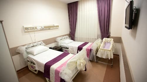 <font face="arial,helvetica,sans-serif" size="2">Uygulama sayesinde doğum sonrasında yoğun bakıma alınan bebekler, annelerinden ayrılmıyor. 5 yıldızlı otel konforuna sahip odalarda ağırlanan annelerin &ccedil;ocuklarını emzirmeleri sağlanıyor. Anneler tedavi s&uuml;recinde bebeklerini tablet bilgisayarlardan 24 saat boyunca izleyebiliyor.<br /><br />T&uuml;rkiye'nin ilk anne otelinin a&ccedil;ılışında konuşan Sağlık Bakan Yardımcısı Agah Kafkas, yoğun bakıma alınan bebeklerin anne s&uuml;t&uuml;nden mahrum kalması nedeniyle b&uuml;y&uuml;k sıkıntıların yaşandığını s&ouml;yledi. 'Anne oteli' uygulamasıyla bebeğin anne s&uuml;t&uuml;nden mahrum kalmayacağını kaydeden Kafkas, &quot;Yoğun bakımda anne ve &ccedil;ocukları koparıyorduk. Başlangı&ccedil;ta koparıyorduk. Bu anne s&uuml;t&uuml;n&uuml;n engellenmesi nedeniyle b&uuml;y&uuml;k bir sıkıntı oluşturuyordu. Bu nedenle 'anne oteli' dediğimiz bu uygulama bundan sonra yapılacak sağlık komplekslerinde olacak.&quot; dedi. Kafkas, &ouml;zellikle kırsal b&ouml;lgelerde anneleri doğumdan bir hafta &ouml;nce kent merkezine getirip otele yerleştirdiklerini, doğumdan sonra da evlerine d&ouml;nmelerini sağladıklarını ifade etti.<br /><br />Yenidoğan uzmanı Taner Hafızoğlu ise anne otelinin &ouml;nemli bir boşluğu dolduracağını s&ouml;yledi. Bir anne i&ccedil;in en zor durumun bebeğinden ayrılması olduğunu dile getiren Hafızoğlu, şunları ifade etti: &quot;Bebek yoğun bakımdayken annesinden ayrı kalıyordu. Bu durum hem anne hem de bebeğin sağlığını etkileyebiliyor. Annede depresyon oluşuyor. S&uuml;t salgısında azalma meydana geliyor. Bu direkt bebeğin sağlığını ve bakımını etkiliyor.&quot;<br /><br />Yenidoğan yoğun bakımda, anne ve bebeği evde tutmuş gibi 'hastane ortamında otelcilik hizmetiyle anne ve bebek sağlığının en &uuml;st seviyede sağlanabileceği bir sistem kurulduğunu anlatan Hafızoğlu, uygulama hakkında şu bilgileri verdi: &quot;En &uuml;st seviyede bir hizmet veriyoruz. 6 odamız var. Odalarda anne ve bebekler i&ccedil;in her şey mevcut. Yoğum bakım tedavisi g&ouml;ren ve emebilecek d&uuml;zeyde olan bebekler, emzirme zamanlarında annesinin yanına g&ouml;t&uuml;r&uuml;l&uuml;yor. Tedavi s&uuml;recinde anne odasından tablet bilgisayarla bebeğini izleyebiliyor. Anne bebeğiyle baş başa olduğunda acil bir durumda acil butonuna basarak personeli &ccedil;ağırabiliyor. Uygulamayla anne ve bebeği yoğun bakım şartlarında yakınlaştırmış oluyoruz. Bu uygulama T&uuml;rkiye'de ilk.&quot;<br /><br />Anne otelinde misafir edilen Ayşeg&uuml;l Karg&uuml;n ise uygulamanın memnuniyet verici olduğunu s&ouml;yledi. Bebeğinden ayrılmanın kendisi i&ccedil;in &ccedil;ok zor olduğunu belirten Karg&uuml;n, ş&ouml;yle konuştu: &quot;Bebeğim 20 g&uuml;nl&uuml;k. Kontrol i&ccedil;in getirdim. Tedavi i&ccedil;in yoğun bakıma yatırdılar. Evden gelip gitmek zor oluyor. G&ouml;remeyince bir anne olarak &uuml;z&uuml;l&uuml;yor insan. Ancak &ccedil;ocuğumun yanında kalmak &ccedil;ok g&uuml;zel. Emzirmek i&ccedil;in buradayım. İla&ccedil; i&ccedil;in alıp g&ouml;t&uuml;r&uuml;yorlar.&quot;</font>