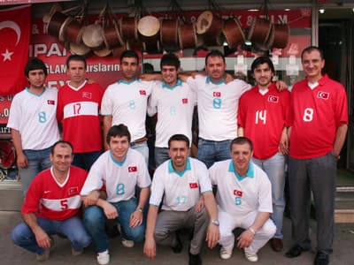 <font face="verdana,geneva" size="2">Kazansa da, kaybetse de y&uuml;reğimiz, sevgimiz onlarla olacak. Bu noktaya gelip bize b&uuml;y&uuml;k sevin&ccedil; yaşattılar. Bundan sonra da yolları a&ccedil;ık olur, biz de Viyana'daki finalde onları <strong>90 dakika &ccedil;ılgın gibi</strong> desteklemek i&ccedil;in orada oluruz. Bu desteğin en g&uuml;zel &ouml;rneklerinden biri şehrimizde, Dar sokaktaki esnaf arasında yaşandı. <br /><br />Bosch bayii <strong>Erdoğan &Ouml;ner Ticaret</strong> ve <strong>Turkcell Bayii &Ouml;zb&uuml;lb&uuml;ller İletişim</strong> &ccedil;alışanları başta olmak &uuml;zere sokaktaki bir &ccedil;ok esnaf, g&uuml;n boyu&nbsp; &uuml;zerlerinde T&uuml;rk Milli Takımının formaları ile işlerine devam ettiler. <br /><br />B&ouml;ylece hem takımımıza olan desteklerini yansıttılar hem de m&uuml;şterilerine farklı bir g&uuml;n yaşattılar. Onların bu desteklerini g&ouml;n&uuml;lden kutluyor, bu farklılığın yarı final ma&ccedil;ı ile devam etmesini temenni ediyoruz. </font>