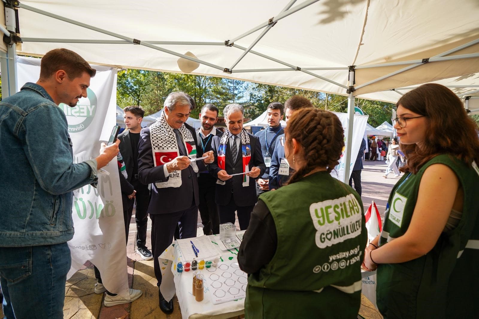 Sakarya Üniversitesi (SAÜ), öğrencilerin sosyal ve akademik gelişimlerine katkı sağlayan öğrenci topluluklarını, yeni üyeleriyle tanıştırmak için stantlarını açtı.
2025-2026 akademik yılının başlamasıyla birlikte, kampüsün en heyecan verici etkinliklerinden biri olan "Öğrenci Toplulukları Tanıtım Etkinliği" başladı. Esentepe Kampüsü'ndeki yürüyüş yolu boyunca sıralanan stantlarda, farklı alanlarda faaliyet gösteren tam 70 öğrenci topluluğu yer aldı.
Kültür ve sanat, spor, teknoloji, sosyal sorumluluk projeleri gibi geniş bir alanda etkinlikler düzenleyen topluluklar, yeni öğrencilere kendilerini tanıtma ve faaliyetlerini anlatma fırsatı buldu. Etkinlik alanını ziyaret eden Sakarya Büyükşehir Belediye Başkanı Yusuf Alemdar ve Sakarya Üniversitesi Rektörü Prof. Dr. Hamza Al, toplulukların stantlarını gezerek yürüttükleri projeler hakkında bilgi aldı. Ayrıca, Yusuf Alemdar ve Prof. Dr. Al, topluluk temsilcileriyle sohbet ederek projeleri ve gelecek dönem hedefleri hakkında fikir alışverişinde bulundu.
Bu yılki tanıtım etkinliğinin en ilgi çekici yanlarından biri, yeni kurulan 10 öğrenci topluluğunun ilk kez öğrencilerle buluşmasıydı. Yeni katılımlarla birlikte SAÜ’deki toplam topluluk sayısı 70'e yükseldi. Bu gelişme, öğrencilere çok daha fazla seçenek sunarak farklı ilgi alanlarına hitap ediyor. Topluluk temsilcileri, stantlarını ziyaret eden öğrencilere yıl boyunca gerçekleştirecekleri etkinlikler, projeler ve eğitimler hakkında bilgi vererek üye kayıtlarını almaya başladı.
Öğrenciler, tanıtım etkinliği sayesinde hem ders dışı zamanlarını verimli bir şekilde değerlendirme hem de sosyal çevrelerini genişletme fırsatı buluyor. Stantlar, 17 Ekim'e kadar kampüs yürüyüş yolunda ziyaretçilere açık olacak.